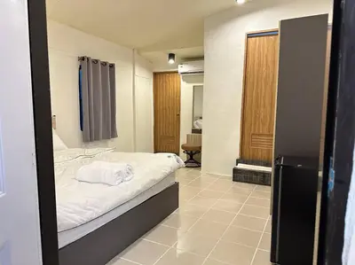 a bedroom with a bed with white sheets at Chubby 5 Room 5 in Bangkok