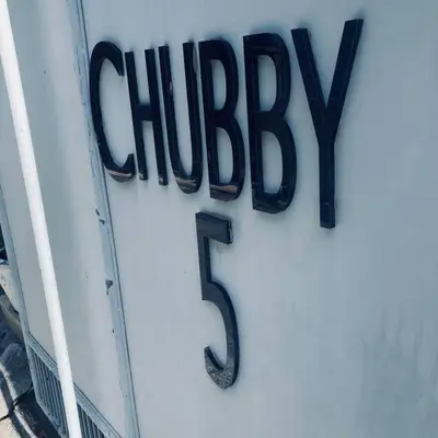 a sign for a chicken sign on a building at Chubby 5 in Bang O