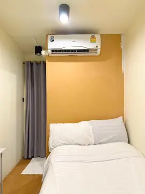 a bedroom with a bed with a air conditioner on the wall at Chubby 5 in Bang O
