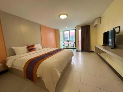 a hotel room with a bed and a television at Aryan Suites Hotel in Bangkok