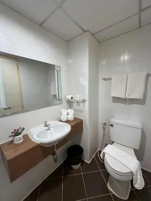 a bathroom with a white toilet and a sink at Aryan Suites Hotel in Bangkok