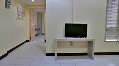 a television sitting on a table in a room at Aryan Suites Hotel in Bangkok
