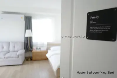 a living room with a white couch and a sign at TATCHA HOUSE 3BR, Central Westgate, Nonthaburi in Ban Lat Pla Duk