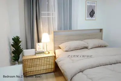 a bedroom with a bed and a table with a lamp at TATCHA HOUSE 3BR, Central Westgate, Nonthaburi in Ban Lat Pla Duk