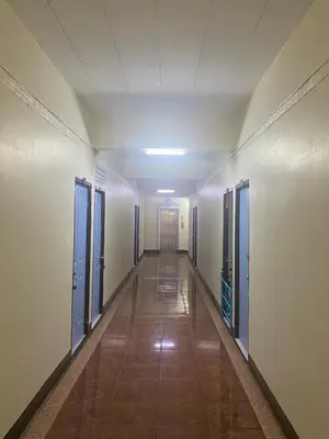 an empty hallway with blue doors and a long corridor at Suppamas Mansion ศุภมาส แมนชั่น in Bangkok Yai