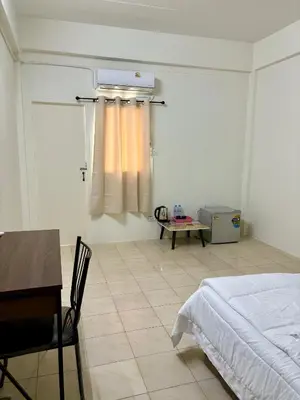 a bedroom with a bed and a desk and a table at Suppamas Mansion ศุภมาส แมนชั่น in Bangkok Yai