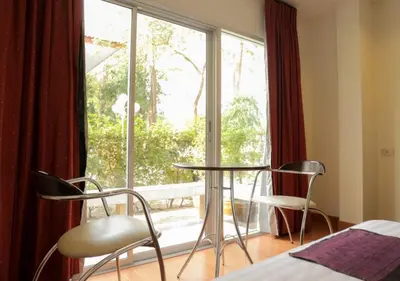 a room with two chairs and a table and a window at Kiatthada Resort in Bangkok