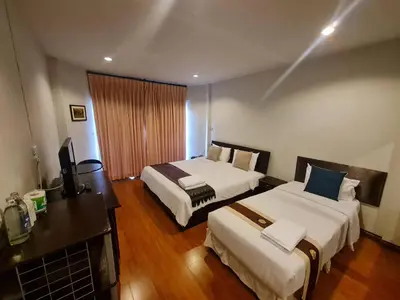 a hotel room with two beds and a television at Kiatthada Resort in Bangkok