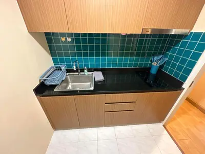 a kitchen with a sink and a green tiled wall at 2bd Apartment near icon Siam close to Everything in Bangkok