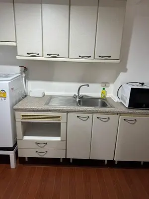 a small kitchen with a sink and a refrigerator at Fully Furnished Omni Tower Apartments Nana - Sukhumvit soi 4 in Bangkok