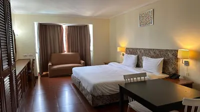 a hotel room with a bed and a desk at Fully Furnished Omni Tower Apartments Nana - Sukhumvit soi 4 in Bangkok