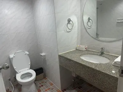 a bathroom with a toilet and a sink and a mirror at Fully Furnished Omni Tower Apartments Nana - Sukhumvit soi 4 in Bangkok