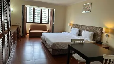 a hotel room with a bed and a table and a chair at Fully Furnished Omni Tower Apartments Nana - Sukhumvit soi 4 in Bangkok