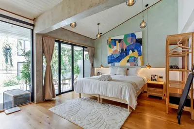 a bedroom with a bed and a painting on the wall at Thai wabi-sabi Loft in Bangkok