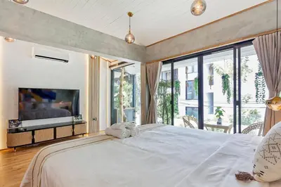 a large bedroom with a large bed and a large window at Thai wabi-sabi Loft in Bangkok