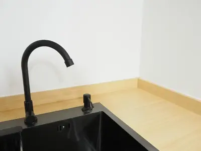 a black sink in a kitchen with a wooden counter at Casa del Toro in Bangkok