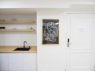 a kitchen with white cabinets and a chalkboard next to a door at Casa del Toro in Bangkok