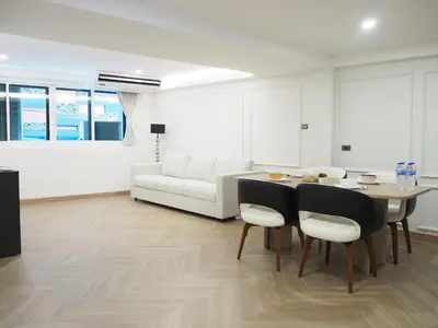 a living room with a table and a white couch at Casa del Toro in Bangkok