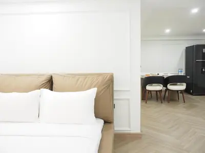 a bedroom with a bed and a living room with chairs at Casa del Toro in Bangkok