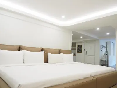 a bedroom with a large white bed with white pillows at Casa del Toro in Bangkok