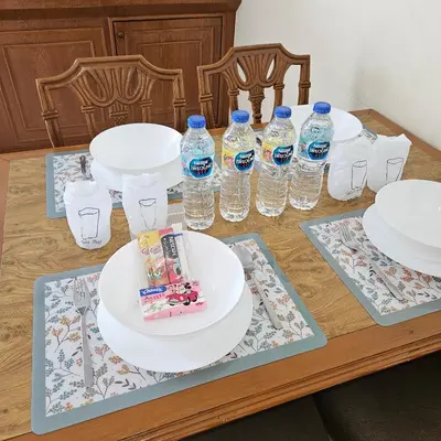 a table with plates and bottles of water on it at Omni Suites 2Bedroom in Bangkok