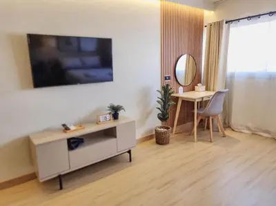 a living room with a tv on a wall at Better Room ห้องพักรายวัน เมืองทองธานี C4 in Ban Bang Phang