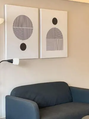 a living room with a couch and two pictures on the wall at Better Room ห้องพักรายวัน เมืองทองธานี C2 in Nonthaburi