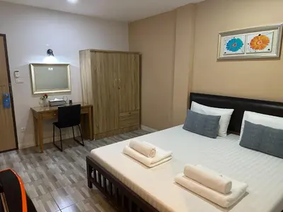 a bedroom with a bed with two towels on it at Baanfahsai in Makkasan