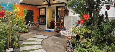 a garden entrance to a house with flowers and plants at Baanfahsai in Makkasan