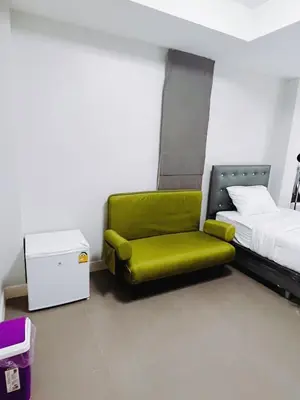a green chair in a room with a bed at XX Mitr Inn The Grand Palace - Mrt Samyot Station มิตร อินน์ พระบรมมหาราชวัง in Bangkok
