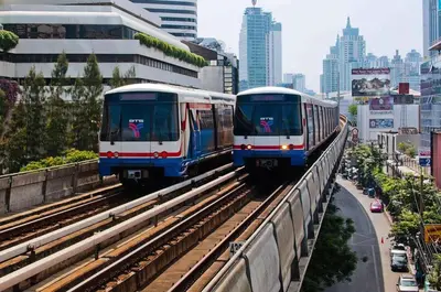 two trains are on the tracks in a city at 108 Quiet and nice fan apartment with full amenities free Wi-Fi in Bangkok