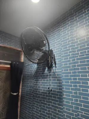 a blow dryer is attached to a blue tiled shower at 108 Quiet and nice fan apartment with full amenities free Wi-Fi in Bangkok