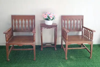 two wooden chairs and a table with a vase of flowers at Happyhouse Laksi station (PK14) in Lak Si
