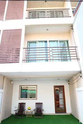 a house with two chairs and a table in front of it at Happyhouse Laksi station (PK14) in Lak Si