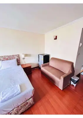 a bedroom with a bed and a chair in it at Affordable Serviced Apartment Nana - Omni Tower Sukhumvit location in Bangkok