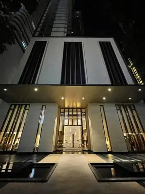 two pictures of a building at night with a door at Ultimate Luxurious in Prime Bangkok Asoke in Bangkok