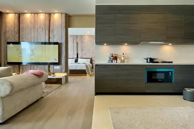 a living room with a couch and a kitchen at Ultimate Luxurious in Prime Bangkok Asoke in Bangkok