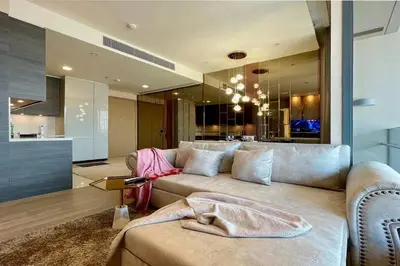 a living room with a couch and a kitchen at Ultimate Luxurious in Prime Bangkok Asoke in Bangkok