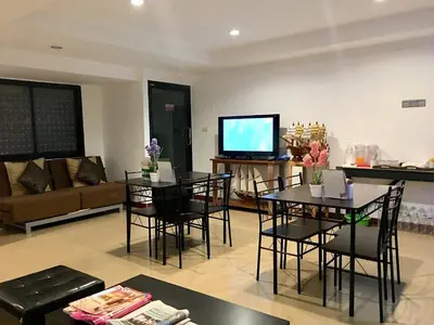 a living room with tables and chairs and a tv at Double DD House at MRT Sutthisarn in Bangkok