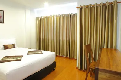 a bedroom with a bed and a desk and curtains at Double DD House at MRT Sutthisarn in Bangkok