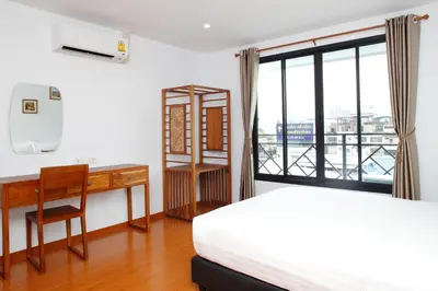 a bedroom with a bed and a desk and a window at Double DD House at MRT Sutthisarn in Bangkok