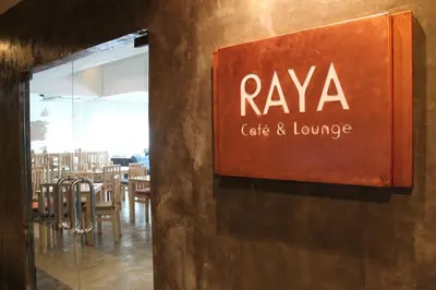 a sign for a cafe and lounge on a wall at The Raya Surawong Bangkok in Bangkok