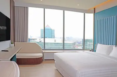 a hotel room with a bed and a large window at The Quarter Ratchayothin by UHG in Bangkok