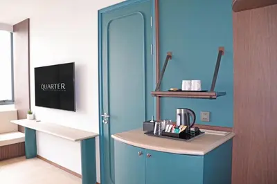 a room with a blue door and a counter with a coffee maker at The Quarter Ratchayothin by UHG in Bangkok