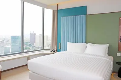 a bedroom with a large white bed and large windows at The Quarter Ratchayothin by UHG in Bangkok