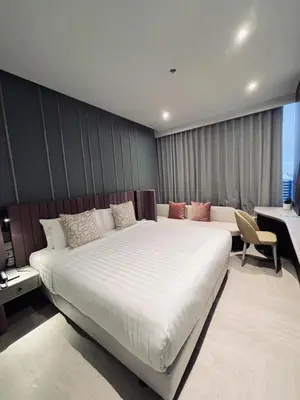 a bedroom with a large white bed and a desk at The Quarter Ratchayothin by UHG in Bangkok