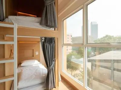 a bedroom with bunk beds and a large window at Cape Ratchada. in Bangkok