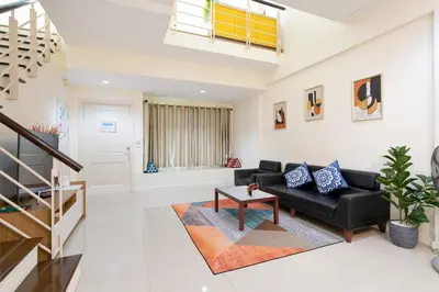 a living room with a black couch and a table at AreeHouse \u66fc\u8c37 300\u5e73\u65b9 \u7368\u68df\u5225\u5885 \u5bb6\u5ead\u9996\u9078 \u8fd17-11 \u8d85\u5e02 MRT in Bangkok