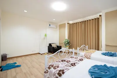 a hotel room with two beds and a chair at AreeHouse \u66fc\u8c37 300\u5e73\u65b9 \u7368\u68df\u5225\u5885 \u5bb6\u5ead\u9996\u9078 \u8fd17-11 \u8d85\u5e02 MRT in Bangkok