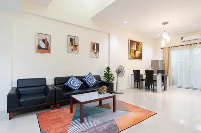 a living room with a black couch and a table at AreeHouse \u66fc\u8c37 300\u5e73\u65b9 \u7368\u68df\u5225\u5885 \u5bb6\u5ead\u9996\u9078 \u8fd17-11 \u8d85\u5e02 MRT in Bangkok